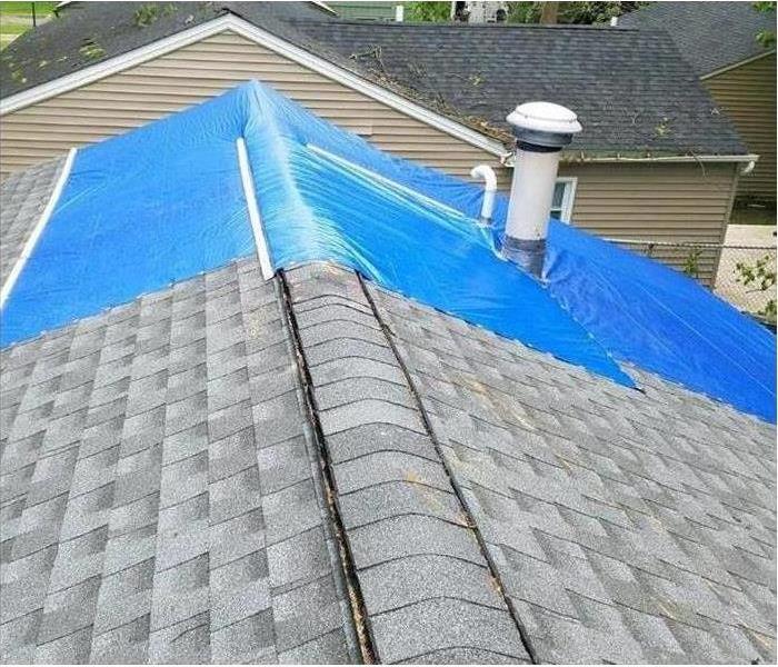 Damage roof covered in blue tarp